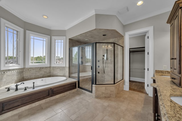 bathroom with a stall shower, ornamental molding, a walk in closet, vanity, and a bath