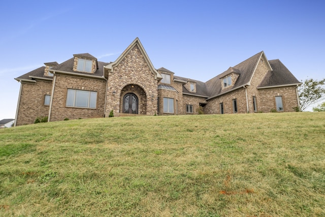 view of front of house with brick siding and a front lawn