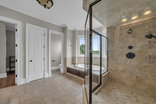 full bath with a garden tub, toilet, ornamental molding, a shower stall, and baseboards