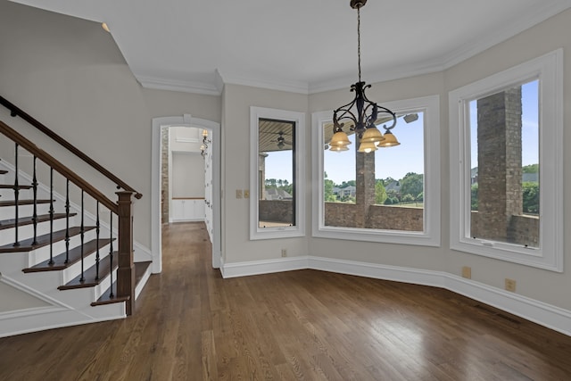 unfurnished dining area featuring ornamental molding, dark hardwood / wood-style flooring, and an inviting chandelier