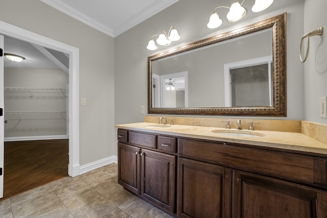 bathroom featuring wood-type flooring, ceiling fan, ornamental molding, and vanity