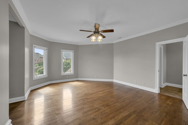 unfurnished room featuring ornamental molding, ceiling fan, dark wood-type flooring, and baseboards