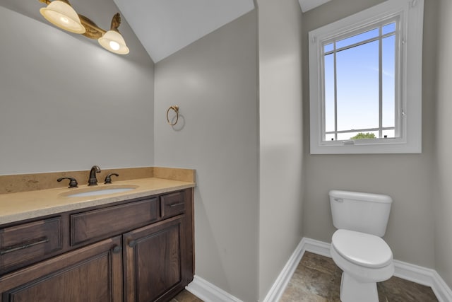 half bath with toilet, lofted ceiling, baseboards, and vanity