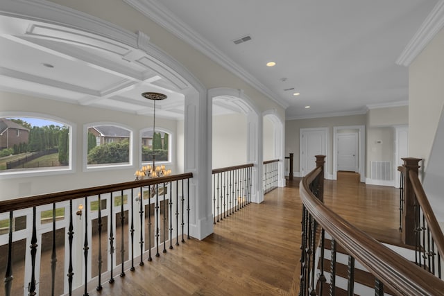 hallway featuring visible vents, coffered ceiling, wood finished floors, an inviting chandelier, and an upstairs landing