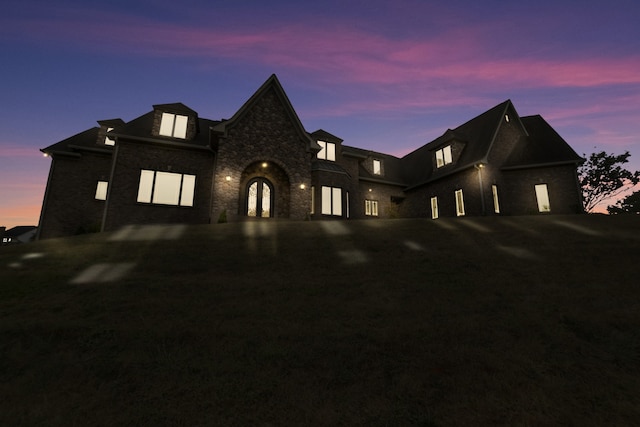 french country style house with driveway and stone siding