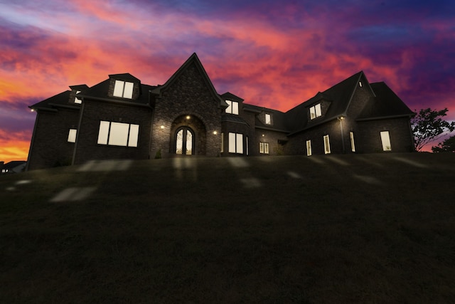 french provincial home featuring driveway and stone siding