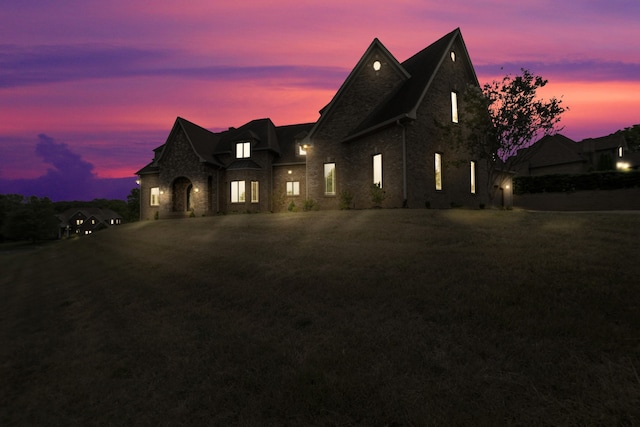 french country home featuring a front yard and stone siding