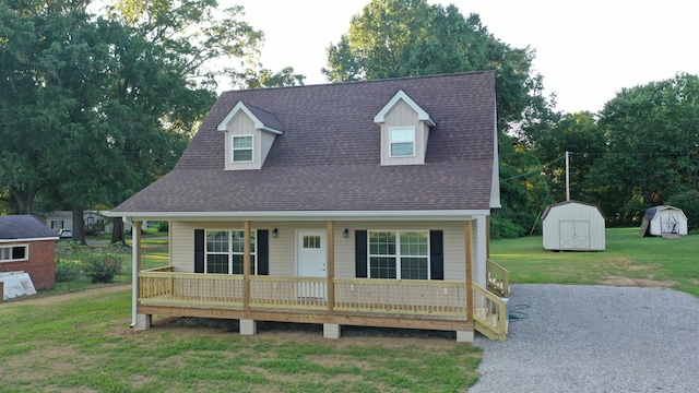 view of front of property featuring a storage unit, a front yard, and covered porch