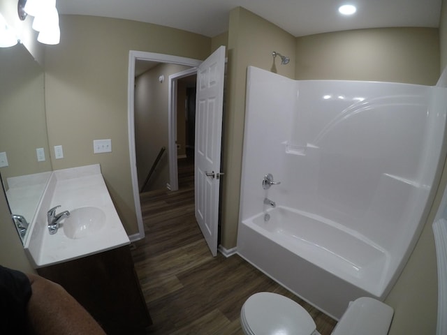 bathroom featuring  shower combination, toilet, wood finished floors, and vanity