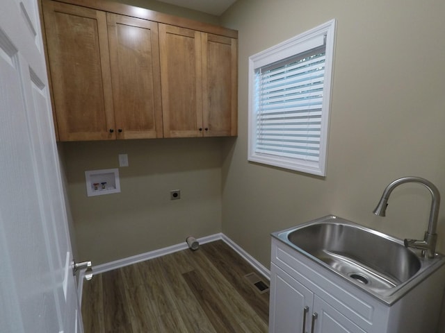 clothes washing area with cabinet space, baseboards, hookup for a washing machine, hookup for an electric dryer, and a sink