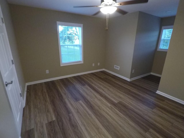 unfurnished bedroom with dark wood-style floors, ceiling fan, visible vents, and baseboards