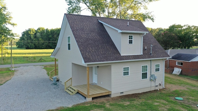 back of property featuring crawl space, roof with shingles, and driveway