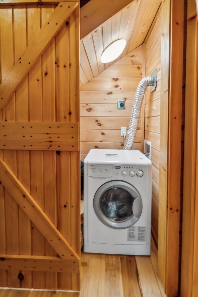 clothes washing area featuring washer / clothes dryer, wood ceiling, light hardwood / wood-style flooring, and wood walls