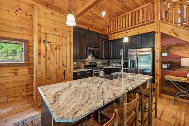 kitchen featuring light wood-type flooring, stainless steel appliances, wood ceiling, and hanging light fixtures