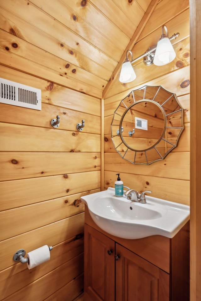 bathroom featuring vaulted ceiling, wood ceiling, wooden walls, and vanity