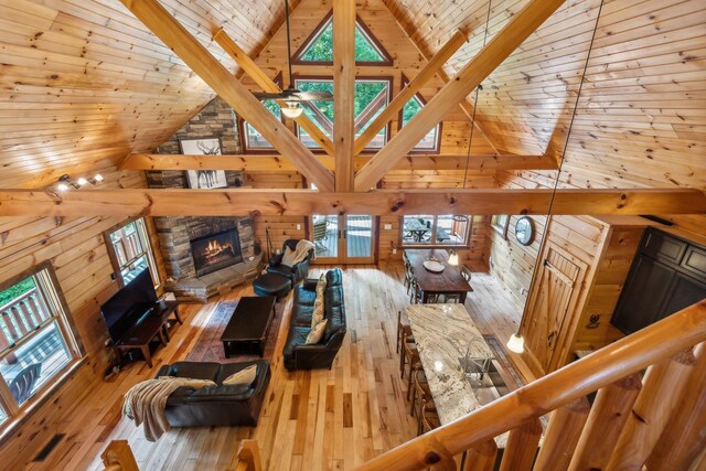 living room featuring a fireplace, wood walls, light hardwood / wood-style floors, and wood ceiling