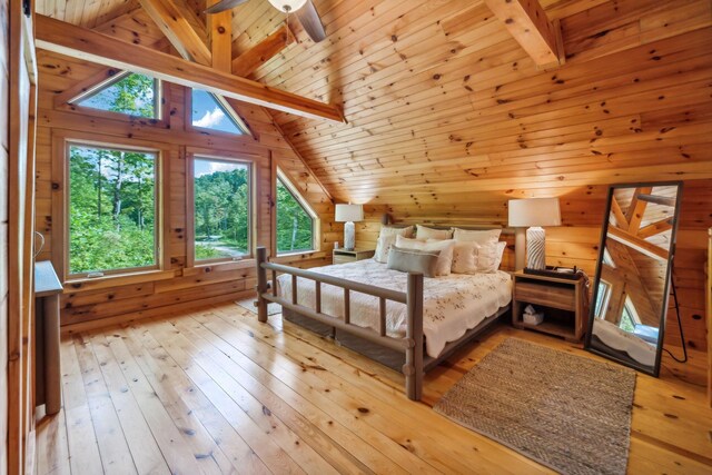 bedroom featuring lofted ceiling with beams, light hardwood / wood-style flooring, ceiling fan, and multiple windows