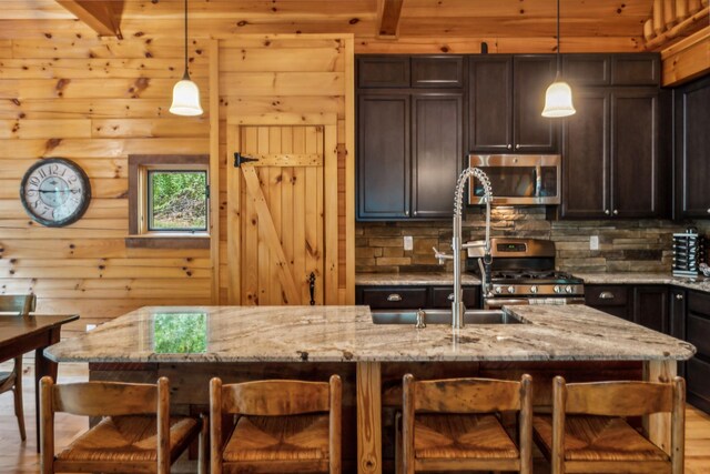 kitchen featuring appliances with stainless steel finishes, light hardwood / wood-style floors, and light stone countertops