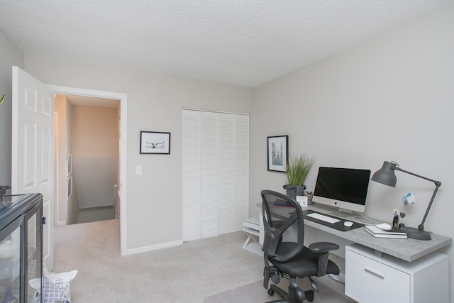 office featuring a textured ceiling and light carpet