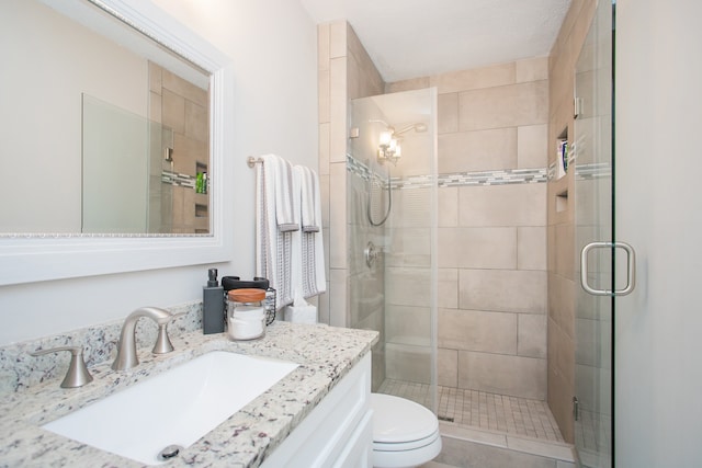 bathroom with toilet, an enclosed shower, and vanity