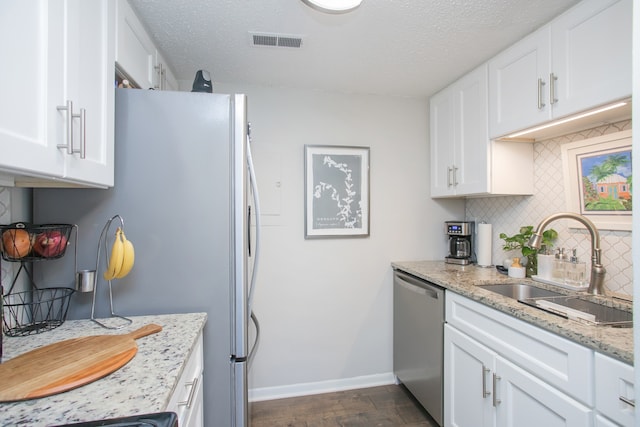 kitchen featuring backsplash, sink, dark hardwood / wood-style floors, dishwasher, and white cabinetry