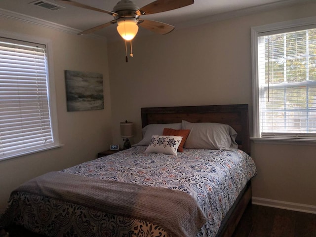 bedroom featuring multiple windows, ornamental molding, hardwood / wood-style flooring, and ceiling fan