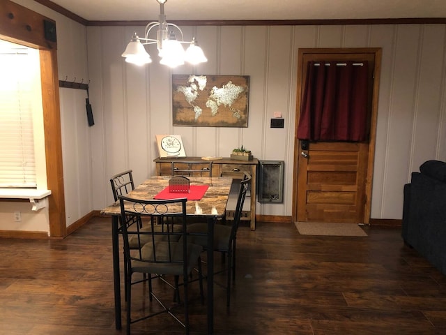 dining room with dark hardwood / wood-style floors, a chandelier, and ornamental molding