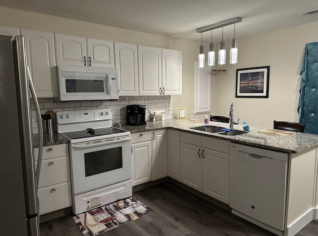 kitchen with white cabinetry, dark hardwood / wood-style floors, sink, kitchen peninsula, and white appliances