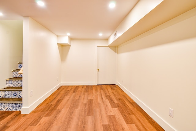 basement with light hardwood / wood-style flooring