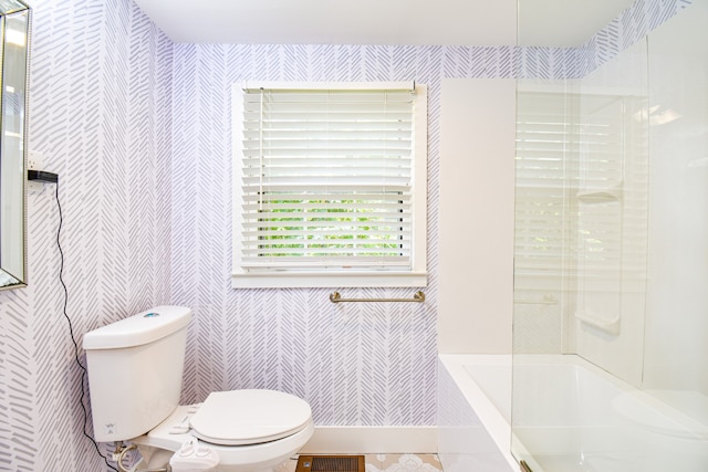 bathroom featuring washtub / shower combination and toilet