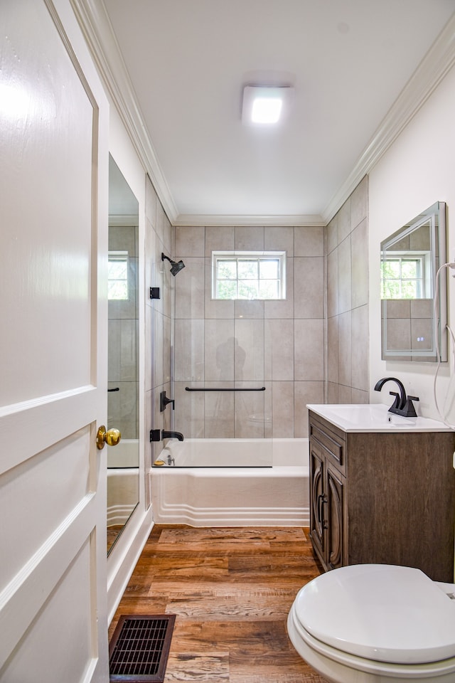 full bathroom featuring crown molding, vanity, a healthy amount of sunlight, and wood-type flooring