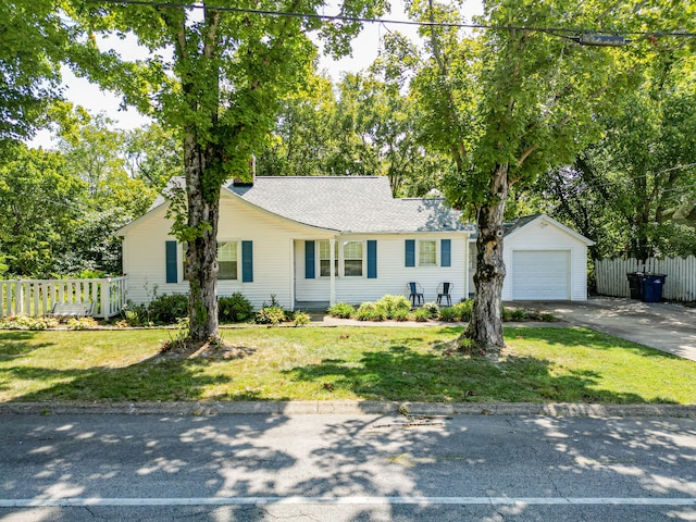 single story home featuring a garage, a front lawn, and an outbuilding