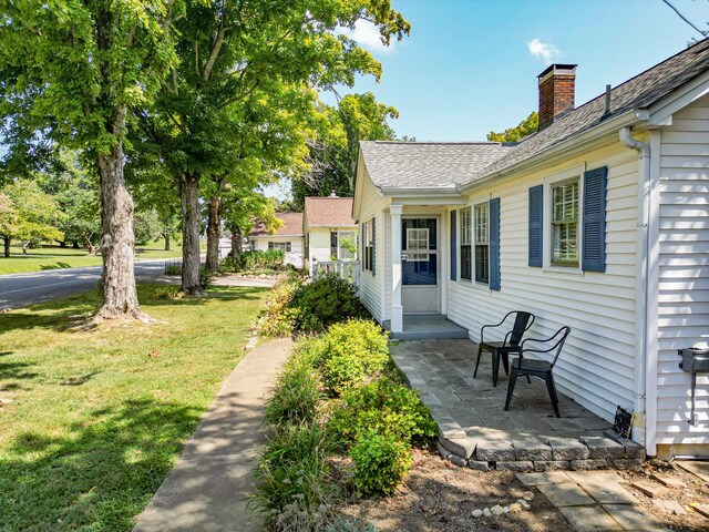 view of side of home with a yard