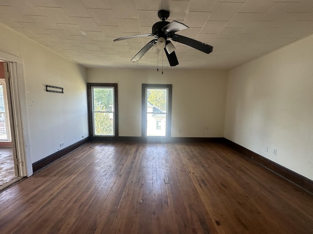 unfurnished room featuring ceiling fan, dark wood-style flooring, and baseboards