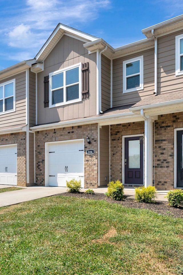 view of property with a garage and a front lawn