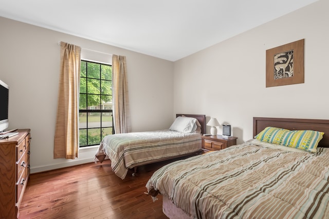 bedroom featuring dark hardwood / wood-style flooring and multiple windows