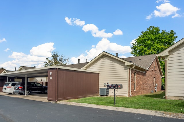 view of side of home with a yard and central air condition unit