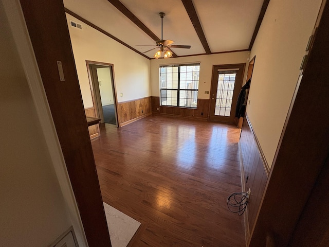 empty room featuring wooden walls, lofted ceiling with beams, ceiling fan, and dark wood-type flooring