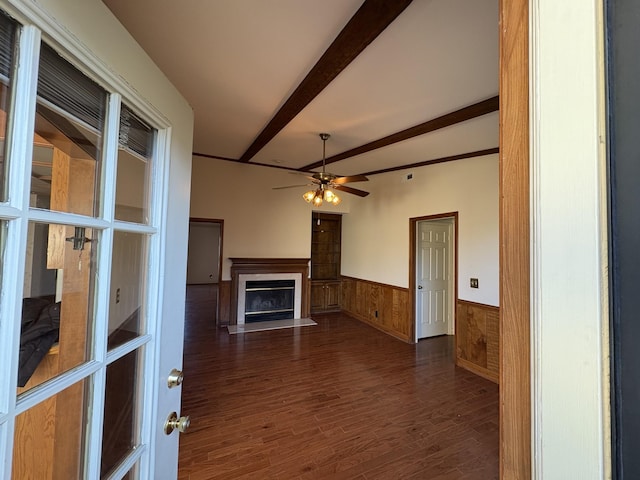 unfurnished living room featuring ceiling fan, beam ceiling, and dark wood-type flooring