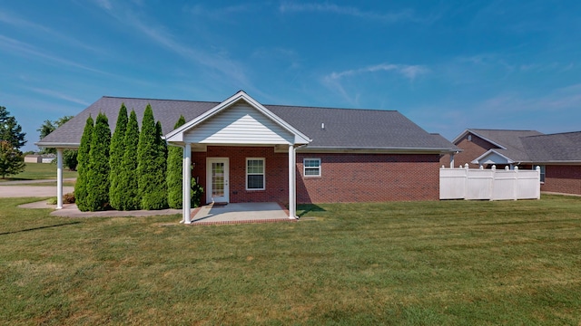 rear view of house featuring a patio area and a yard