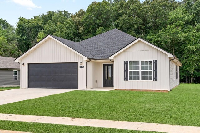 modern farmhouse featuring a garage and a front lawn