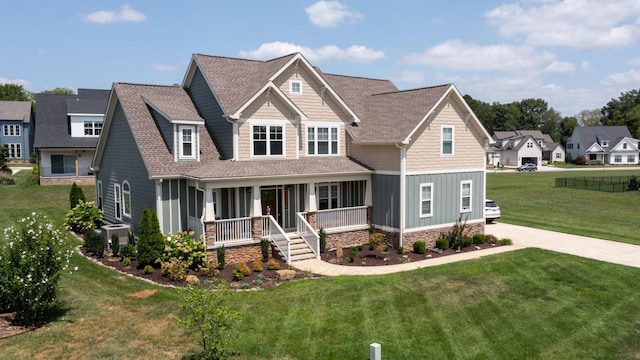 craftsman-style home featuring board and batten siding, covered porch, a front lawn, and roof with shingles