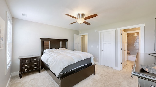 carpeted bedroom with ceiling fan and ensuite bath