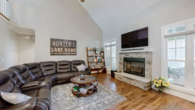 living room with hardwood / wood-style floors, high vaulted ceiling, and a fireplace