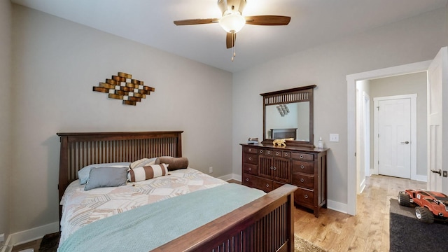 bedroom with light wood-style floors, baseboards, and ceiling fan