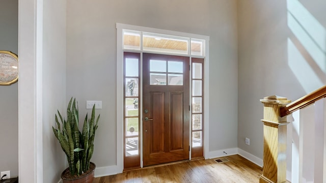 foyer entrance with light wood-type flooring and a healthy amount of sunlight