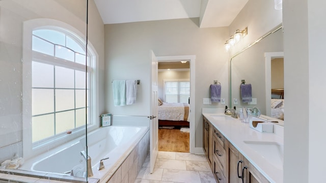 bathroom with vanity, hardwood / wood-style floors, and tiled bath