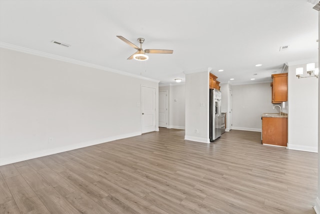 unfurnished living room featuring wood-type flooring, ornamental molding, sink, and ceiling fan