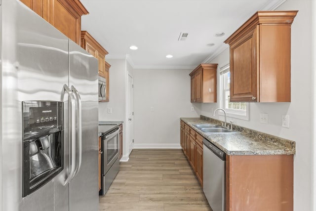 kitchen with stainless steel appliances, light hardwood / wood-style floors, crown molding, and sink