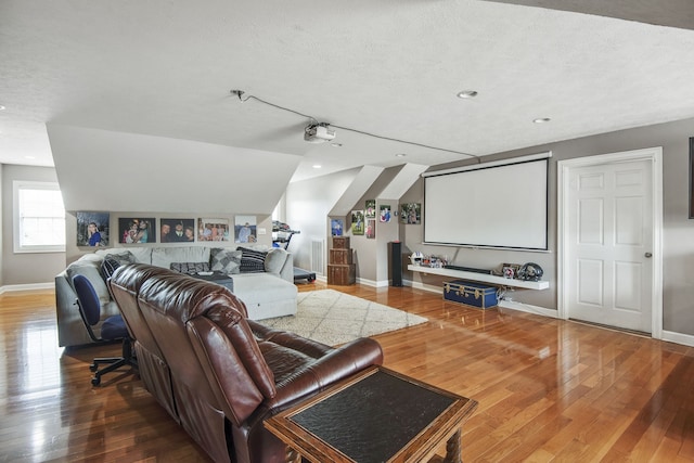 living room featuring hardwood / wood-style flooring, a textured ceiling, and lofted ceiling